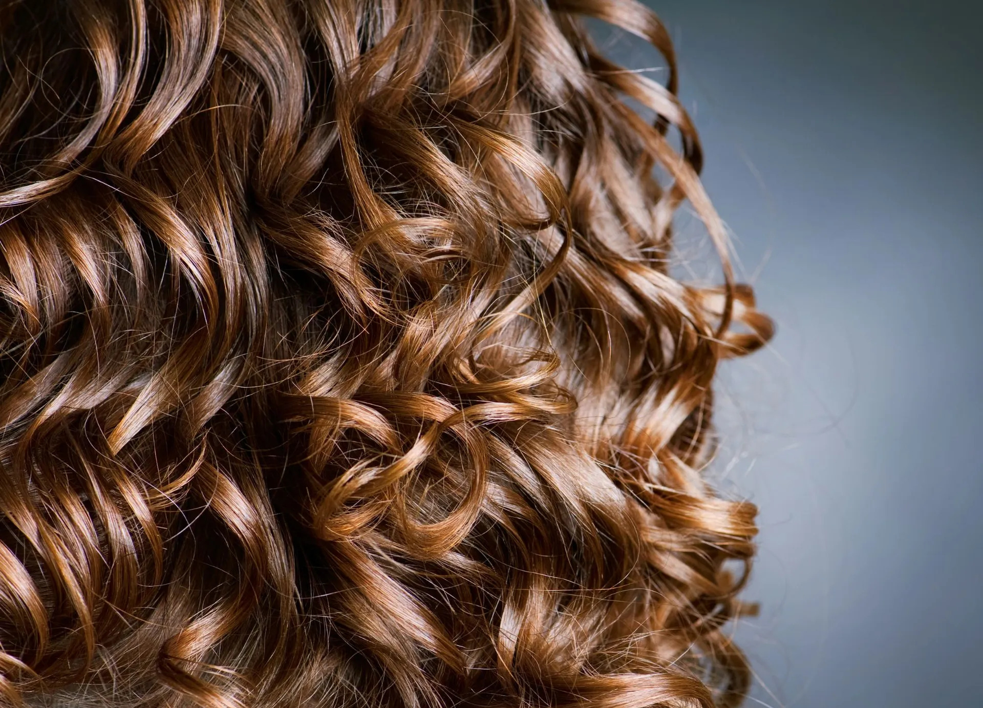 Client with soft permed curls styled at the salon